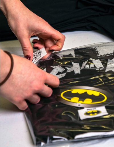 a folded batman t-shirt in a polybag with a barcode sticker by teesh print ltd