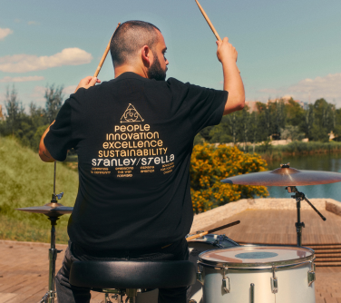 a person drumming wearing a blank band-style stanley stella t-shirt