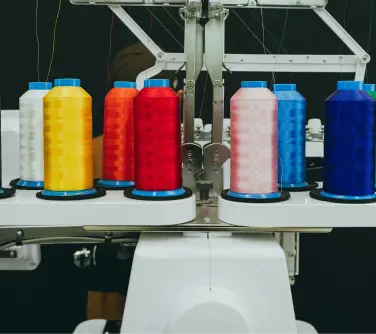 a professional embroidery machine with various spools of thread loaded.
