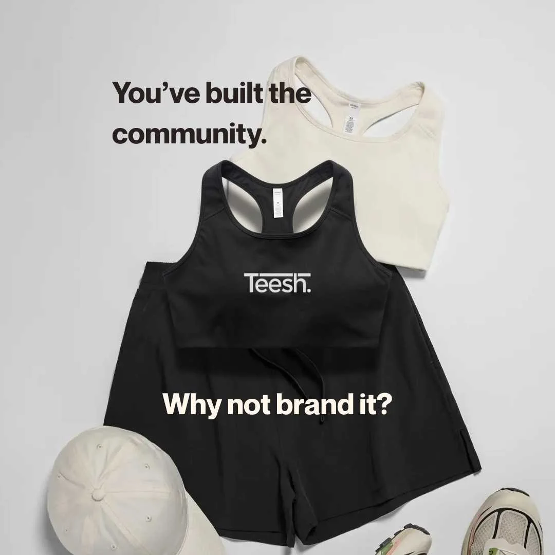 flat lay of activewear blank garments by 'as colour' showing a cream-coloured sports bra, cap, black shorts and trainers on a light grey background.