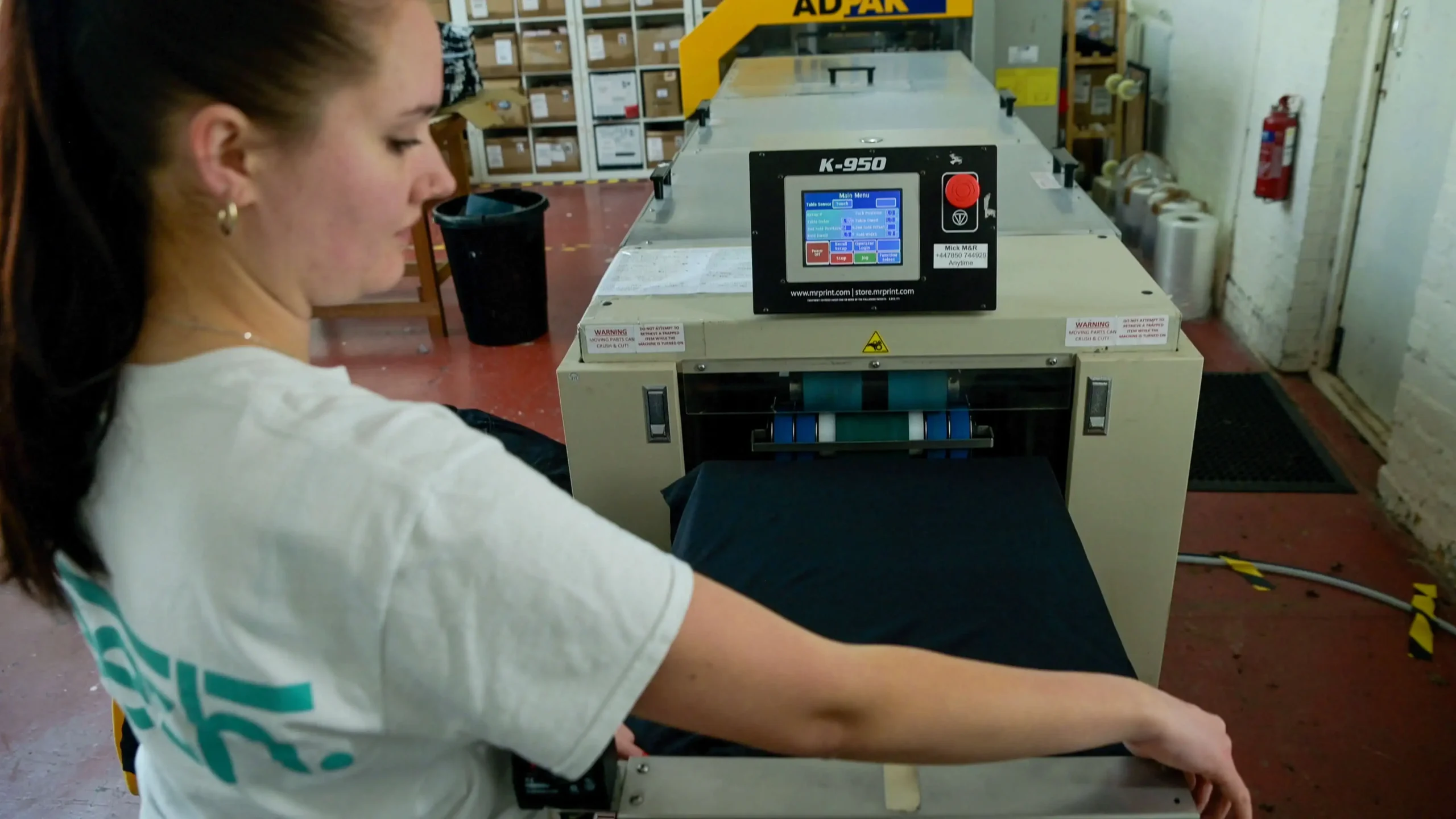 person operating a t shirt folder machine 