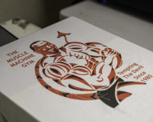 a red and black design of a muscled man with a devil's tail