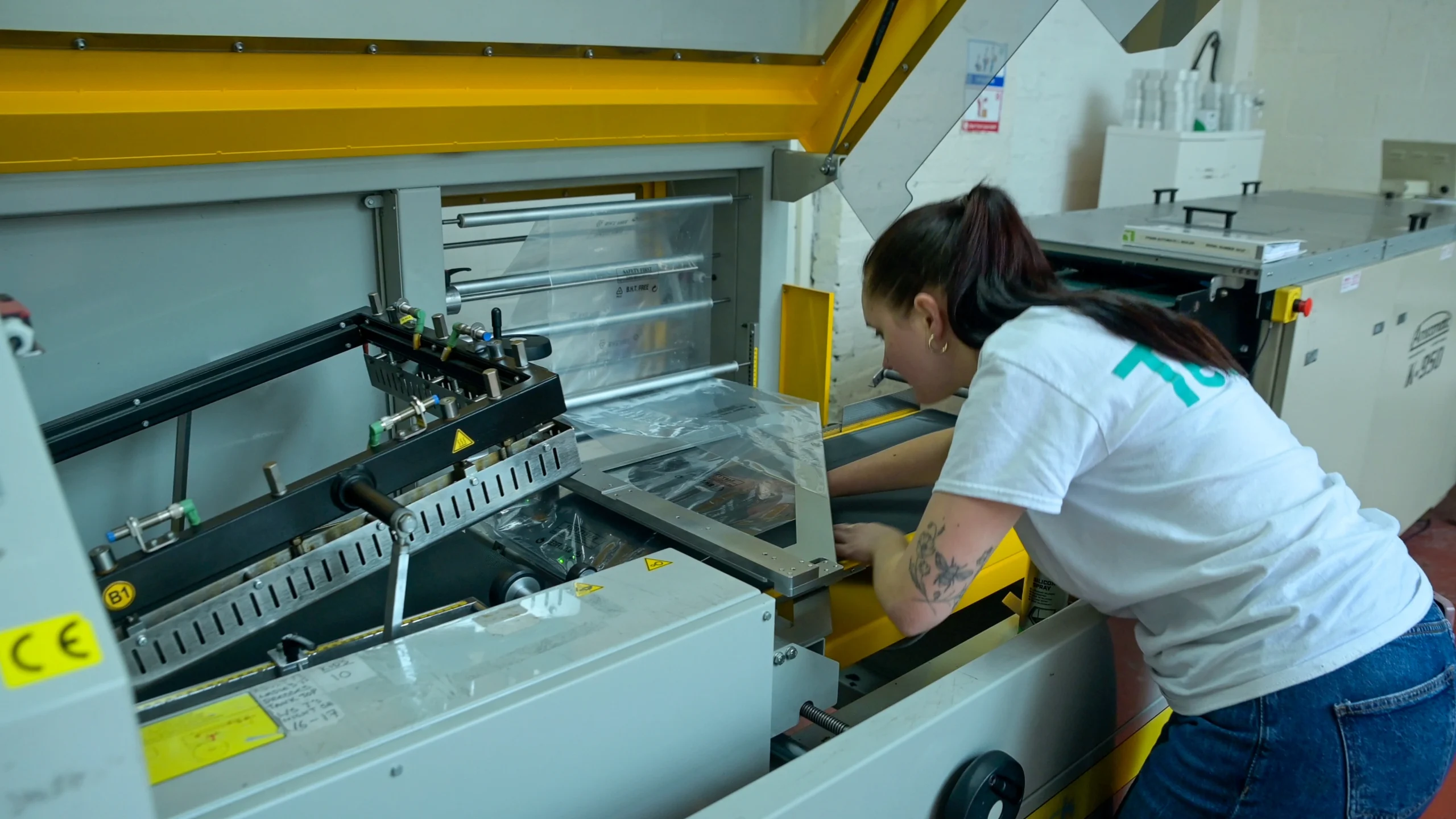 person loading plastic wrap onto a packaging machine