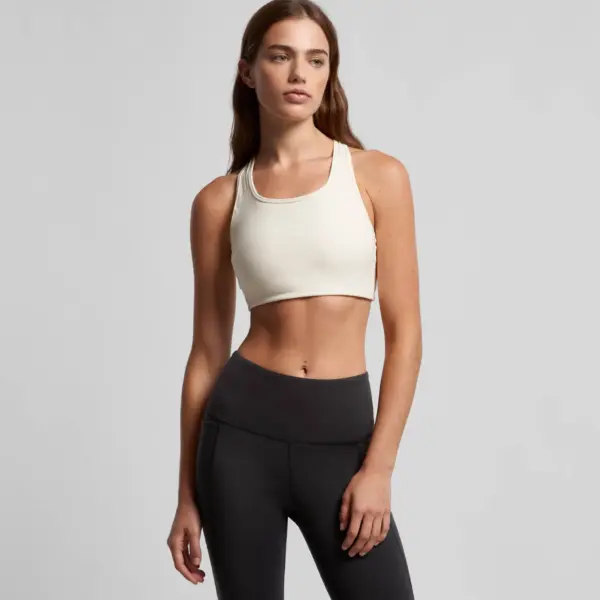 Cream colored athletic crop top with scoop neckline paired with black high-waisted leggings
