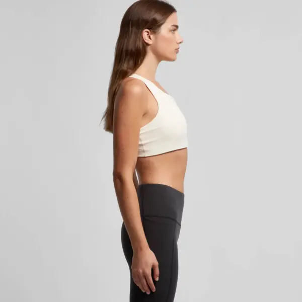 Side profile of cream coloured sports bra with smooth finish and minimalist design for workouts