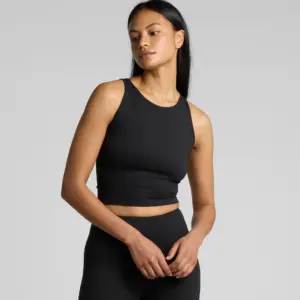 Woman modelling black athletic crop top with high-waisted leggings, minimalist activewear set on light background