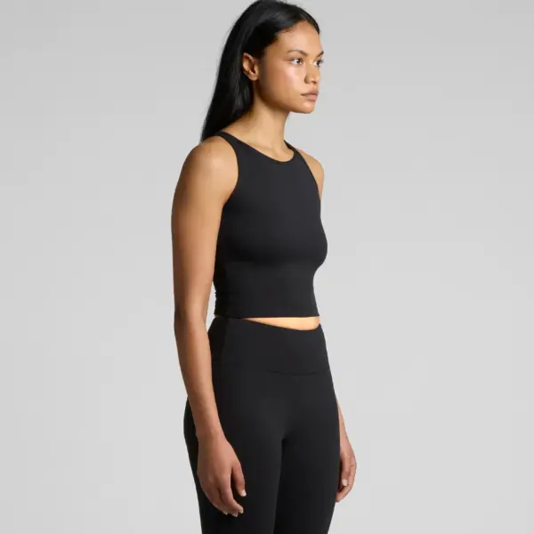 Three-quarter view of woman wearing black workout crop tank with high-waisted leggings, minimalist athletic set