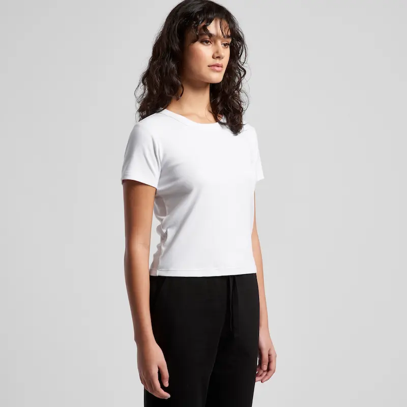 model wearing the as colour baby tee 4074 in white, stood at an angle