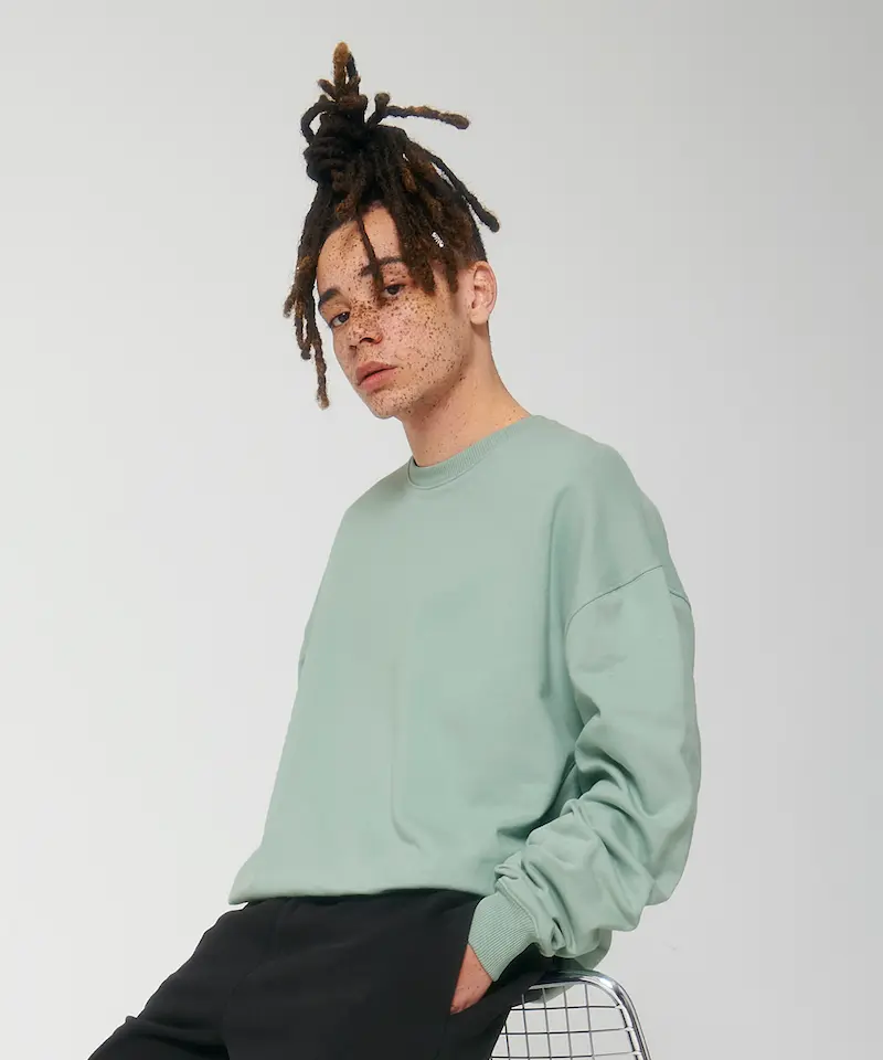 model wearing a sage green stanley stella ledger dry sweatshirt